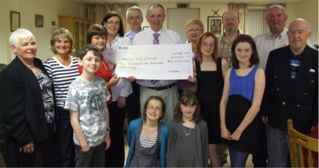 Brothers Leo and Denis McCauley, centre back, present a cheque for €1,100 to Moville Day Centre, proceeds of a charity bridge tournament in memory of their late mother Jane. Also pictured, from left, are Kathleen McDonald and Pauline McQuillan, Moville Bridge Club joint treasurers, Claire McGuinness, Moville Day Centre supervisor and Mary McCauley. Also pictured are Margaret Doherty, club secretary, John Gerard Doherty, club president, John McClenaghan, North West Bridge Association president and Neil McMahon, tournament director. Also included are Leo and Mary's children, James, Jane, Emma, Kate and Sarah.